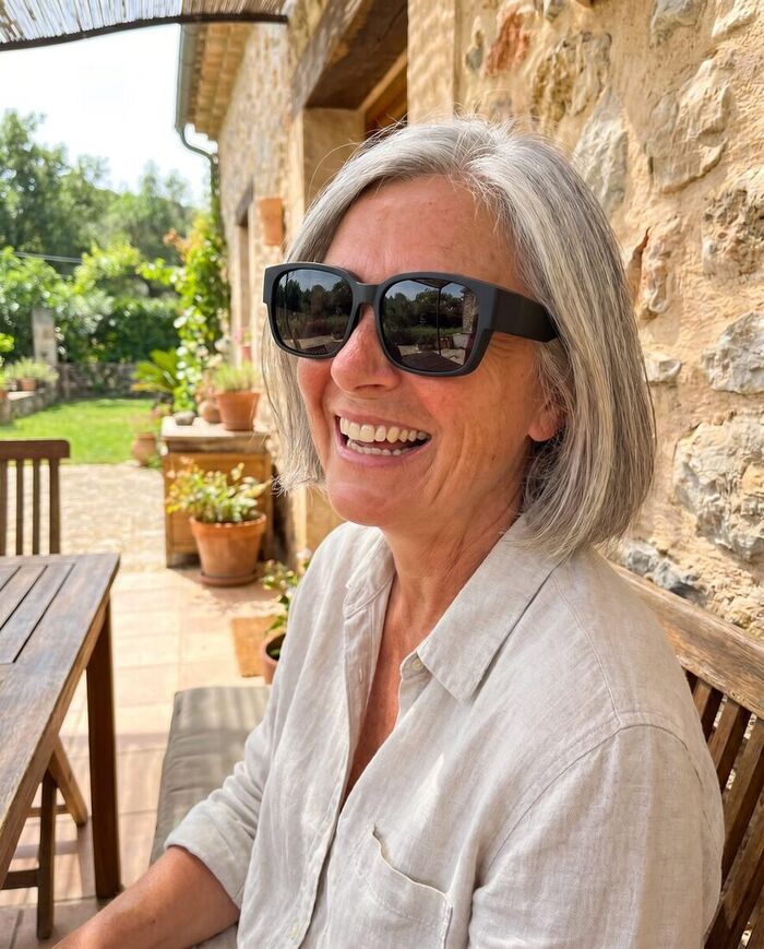 Une utilisatrice porte ses sur-lunettes polarisées Sérénoa en plein soleil sur une terrasse